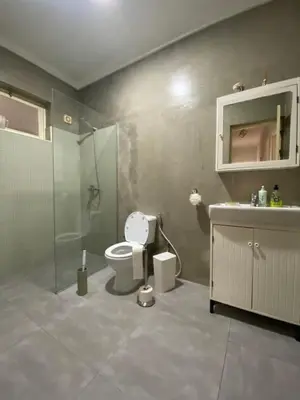 a bathroom with a toilet and a shower and a sink at Casa Aconchego - T2 in Espargos