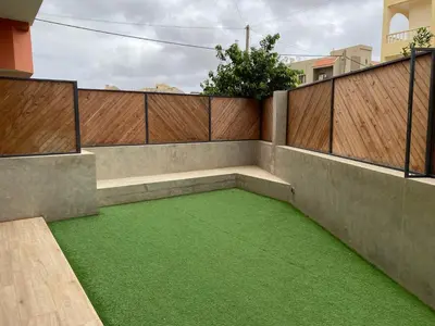 an empty patio with green grass on a fence at Casa Aconchego - T2 in Espargos