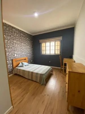 a bedroom with a bed and a brick wall at Casa Aconchego - T2 in Espargos