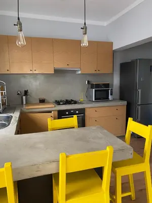 a kitchen with a wooden table and yellow chairs at Casa Aconchego - T2 in Espargos