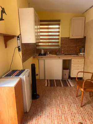 a small kitchen with a refrigerator and a table at sweet single in Santa Maria
