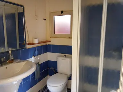 a blue and white bathroom with a toilet and a sink at sweet single in Santa Maria