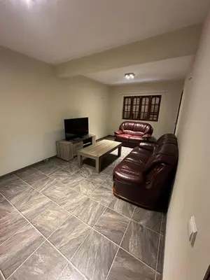 a living room with a leather couch and a table at Casa Lima in Mindelo