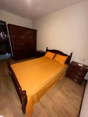 a bedroom with a large bed with an orange bedspread at Casa Lima in Mindelo