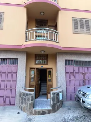 a house with pink doors and a car parked in front at Casa Lima in Mindelo