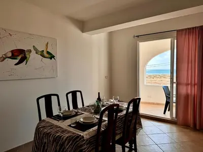 a dining room with a table with chairs and a window at Sea view - Ca Mauro - Praia Cabral - Wi-Fi in Sal Rei