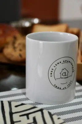 a white coffee cup sitting on a table at Chez Lena, Appartement confortable 3 chambres in Praia