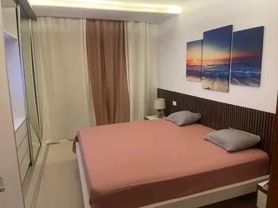 a bedroom with a bed and two paintings on the wall at Chez Lena, Appartement confortable 3 chambres in Praia