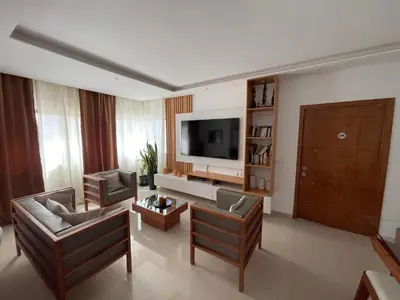 a living room with a couch and a tv at Chez Lena, Appartement confortable 3 chambres in Praia