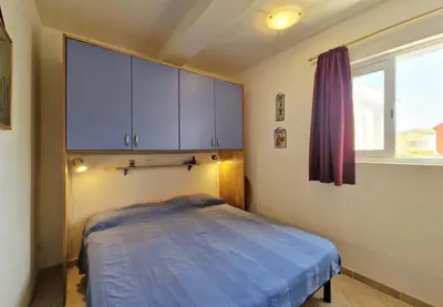 a bedroom with a blue bed and a window at Tommy's Apartment in Santa Maria