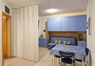 a room with a table and a bed and blue cabinets at Tommy's Apartment in Santa Maria
