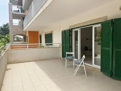 a patio with two chairs and a table on a building at Vida boa é no Vila Verde Sal in Santa Maria