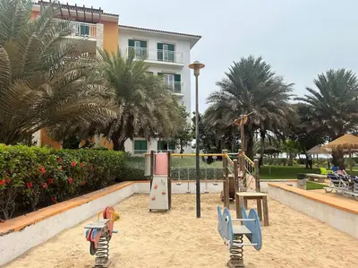 a playground in the sand in front of a building at Vida boa é no Vila Verde Sal in Santa Maria