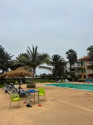 a pool with chairs and a table and an umbrella at Vida boa é no Vila Verde Sal in Santa Maria