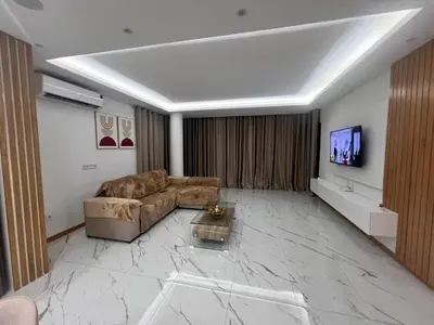 a living room with a couch and a flat screen tv at Ondas Relax House in Praia