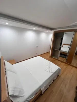 a bedroom with a large white bed and a mirror at Ondas Relax House in Praia