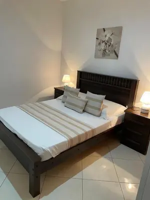 a bedroom with a large bed with pillows on it at Casa Nela grand balcon vitré in Tarrafal