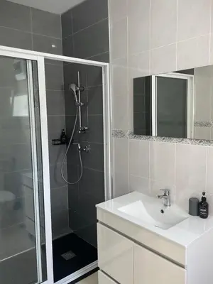 a bathroom with a shower and a sink and a mirror at Casa Nela grand balcon vitré in Tarrafal