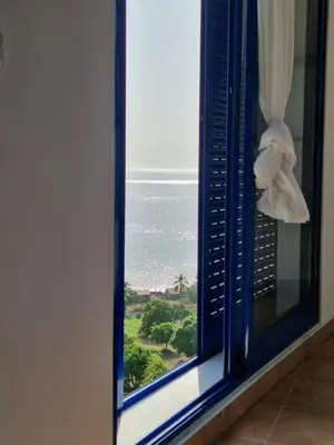 a window with a view of the ocean at Casa Saúde in Seladinha