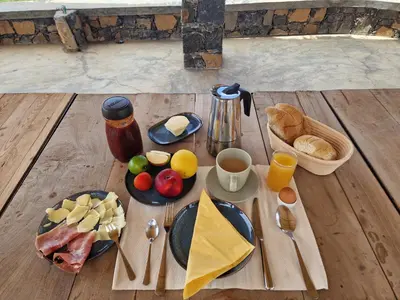 a wooden table with breakfast foods and drinks on it at Casa Saúde in Seladinha