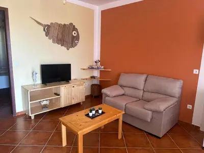 a living room with a couch and a table at Garoupa Stella Maris Apartamento N10 in Vila do Maio