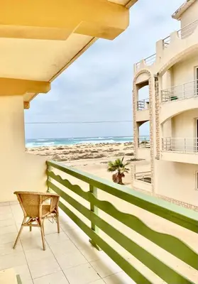 a balcony with a chair and a view of the beach at Vista di mare in Sal Rei