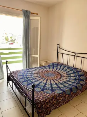 a bed in a bedroom with a window and a bedspread at Vista di mare in Sal Rei