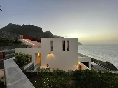 a white house with the ocean in the background at Walhalla Seahouse in Chã da Igreja