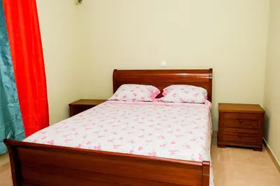 a bedroom with a wooden bed with two pillows at FADIAS Quartos - Rooms in Ribeira Grande