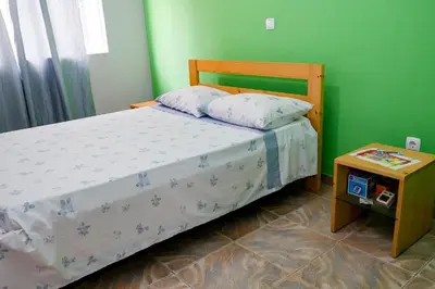 a small bedroom with a bed and a table at FADIAS Quartos - Rooms in Ribeira Grande