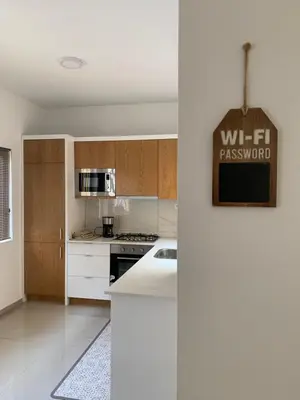 a kitchen with white cabinets and a counter top at Apartamento Moderno in Mindelo