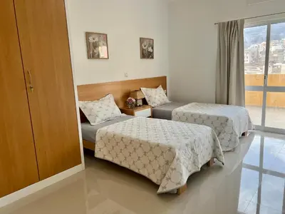 a hotel room with two beds and a window at Apartamento Moderno in Mindelo