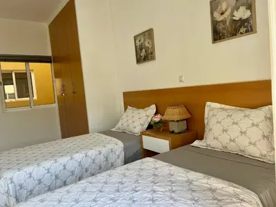 a hotel room with two beds and a table with a lamp at Apartamento Moderno in Mindelo