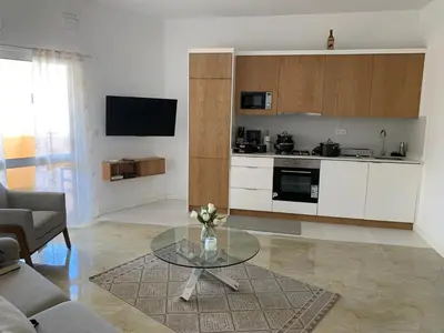 a living room with a table and a kitchen at Apartamento Moderno in Mindelo