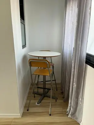 a table and a chair next to a window at Apto Duarte T1 Compacto in Praia
