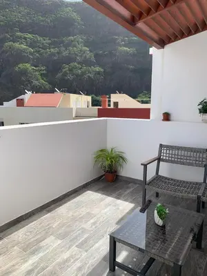 a patio with a bench and a table on a roof at Apartamentos Modernos Santo Antão in Ribeira Grande