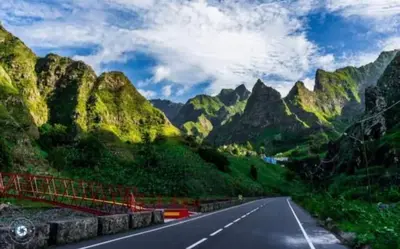 an empty road with mountains in the background at Apartamentos Modernos Santo Antão in Ribeira Grande