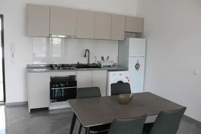 a kitchen with white cabinets and a table and chairs at APARTAMENTO T2 - SAL REI - Boa Vista in Sal Rei