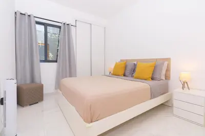 a white bedroom with a bed with yellow pillows at Brand New Spacious T3 Apartment in Santa Maria in Santa Maria