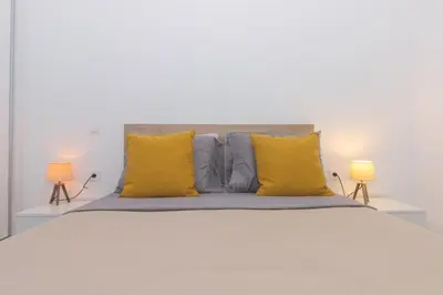 a bedroom with a large bed with yellow pillows at Brand New Spacious T3 Apartment in Santa Maria in Santa Maria