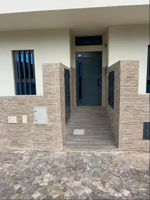 a front door of a building with a stone walkway at Brand New Spacious T3 Apartment in Santa Maria in Santa Maria