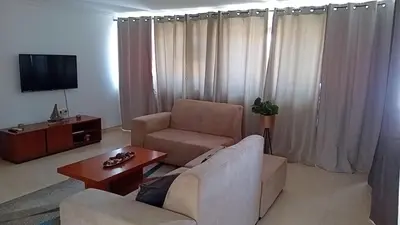a living room with a couch and a chair and a tv at Elite Residences MVT in Praia