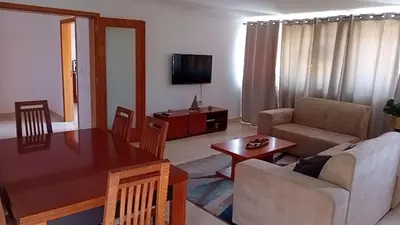 a living room with a table and a couch and a television at Elite Residences MVT in Praia