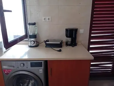a kitchen with a washing machine on a counter at Elite Residences MVT in Praia