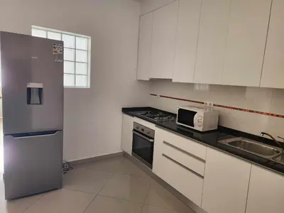 a kitchen with white cabinets and a sink and a microwave at DMSilva in Praia