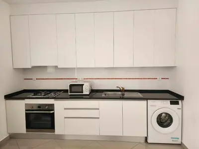 a white kitchen with a sink and a microwave at DMSilva in Praia