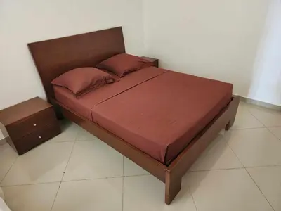 a bed with a wooden headboard and a night stand at DMSilva in Praia