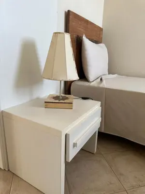 a table with a lamp on it next to a bed at Tropical Paradise in Santa Maria