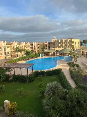 a large swimming pool in a resort with buildings at Tropical Paradise in Santa Maria