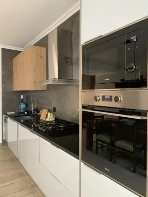 a kitchen with white cabinets and a black counter top at Alfa-apartamento in Pombas